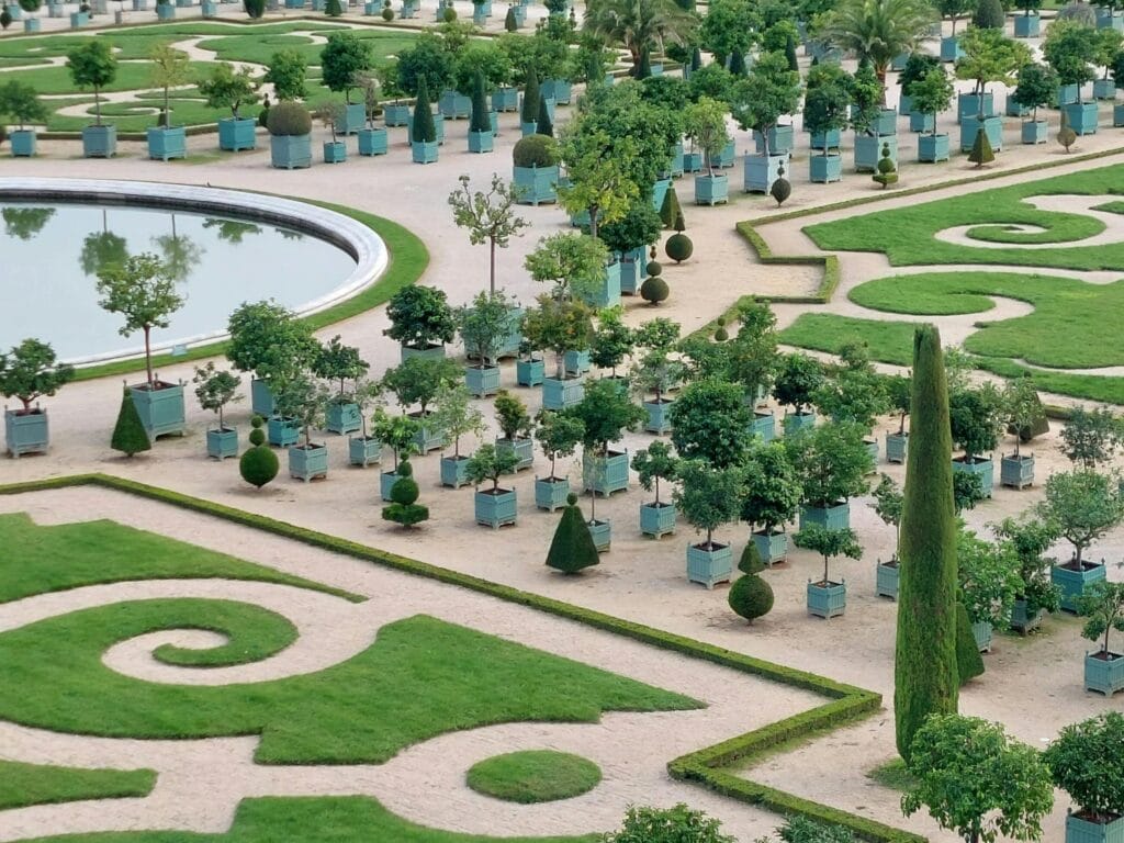 Aerial view of the expansive and intricate gardens of the Palace of Versailles in France. One of the best day trips from paris