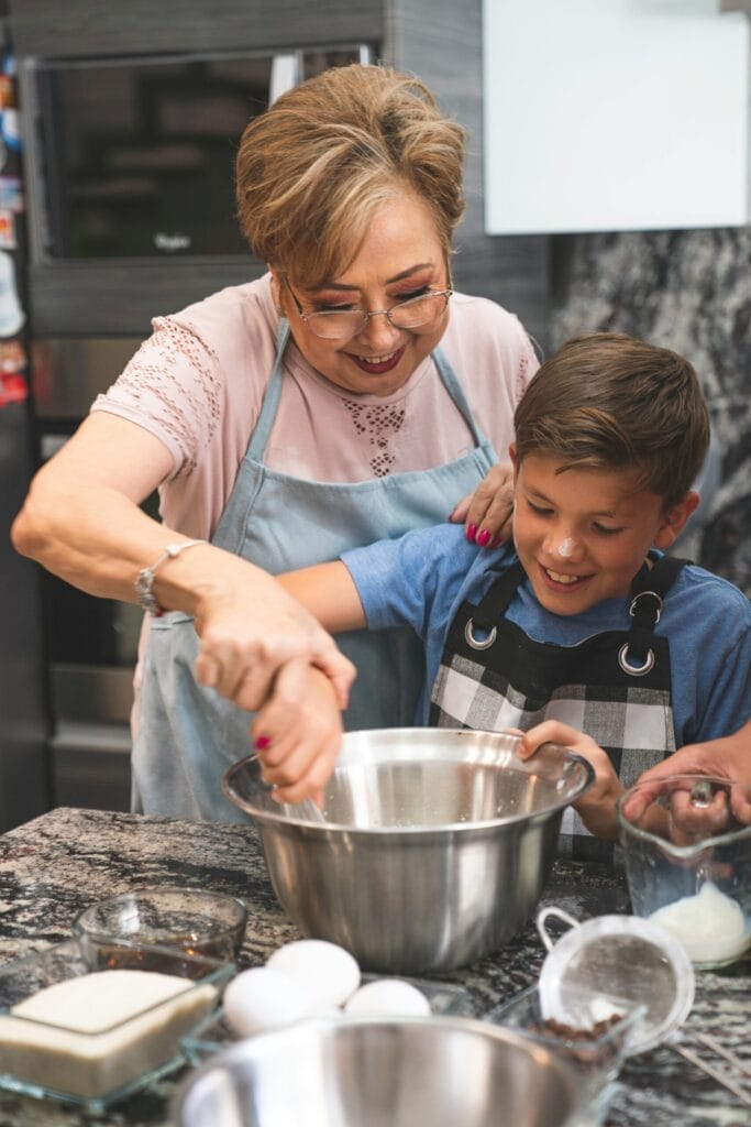 Family Baking Class in Paris – Fun for All Ages Grandmother and grandson enjoying a hands-on family baking class in Paris, learning to make traditional French pastries showcasing paris activities for families